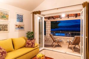 a living room with a couch and a sliding glass door at VILLA AGAPE - Three bedroom villa on 15k m2 olive grove - Incredible 360 view - Free parking - Private pool and jacuzzi in Mirce