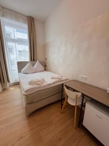 Habitación pequeña con cama y escritorio. en dingdong bonn - city apartments, en Bonn