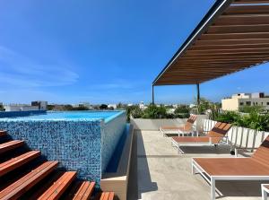a pool with chaise lounge chairs and a swimming pool at Levitat 32 in Playa del Carmen