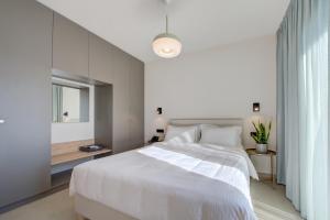 a bedroom with a white bed and a window at Aillo Living Spaces in Ioannina