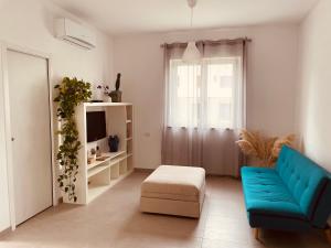 a living room with a blue couch and a tv at Appartamento in villa in Viterbo