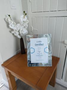 una caja de café certificado sentado en una mesa con un jarrón en Máire Toiréasa – cosy refurbished property in the Gaeltacht Quarter, en Belfast