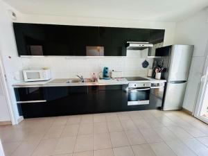 a kitchen with a sink and a refrigerator at T3/4-6pers/5'piedplage/centreville/parking/wifi in Arcachon