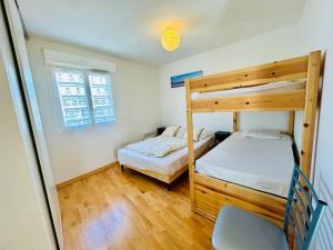 a bedroom with two bunk beds and a chair at T3/4-6pers/5'piedplage/centreville/parking/wifi in Arcachon