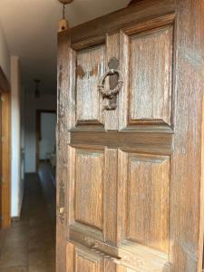 Una vieja puerta de madera con tirador en un pasillo. en Casa La Divisa, en Boceguillas