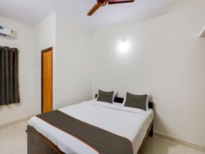 ein Schlafzimmer mit einem großen weißen Bett in einem Zimmer in der Unterkunft OYO Flagship Valasaravakkam in Chennai