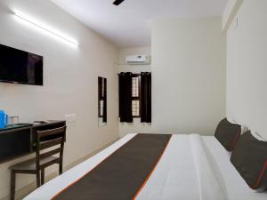 um quarto branco com uma cama e uma secretária em OYO Flagship Valasaravakkam em Chennai