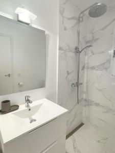 y baño blanco con lavabo y ducha. en Great Duplex Apartment in Marbesa, en Marbella