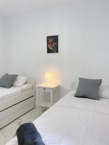 1 dormitorio con 2 camas y mesa con lámpara en Great Duplex Apartment in Marbesa, en Marbella