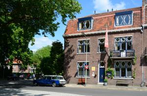 a blue car parked in front of a brick building at Logis Pastis in Maastricht