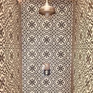 a bathroom with a wallpaper with a light on it at The Nook at Blue Door Barns in Beddingham +1 photo