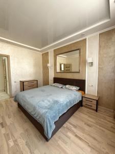 - une chambre avec un grand lit et un miroir dans l'établissement Apartment in Khmelnytsky Street, à Lviv