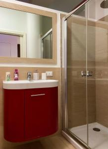 ein Bad mit einem roten Waschbecken und einer Dusche in der Unterkunft La casa di Josephine in Termoli