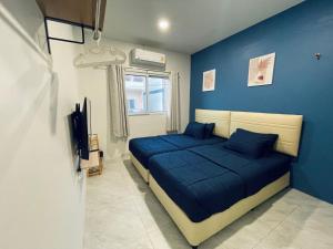 a bedroom with blue walls and a bed with blue pillows at Blue whale Hostel & Café in Pattaya Central