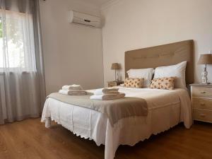 a bedroom with a white bed with towels on it at Santa luzia Tavira 5min walk to Praia do Barril in Tavira