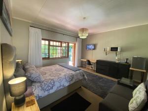 Un dormitorio con una cama, un escritorio y un televisor. en Garden Home in Upper Walmer, en Gqeberha