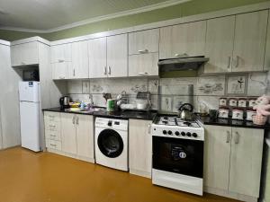 Il comprend une cuisine équipée d'une cuisinière et d'un lave-linge. dans l'établissement STS-Family home guest house, à Samarcande