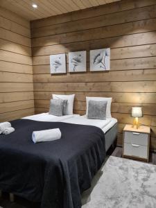 - une chambre avec un grand lit dans un mur en bois dans l'établissement Chalet Ellivuori huoneisto as 1, à Sastamala