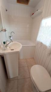 a white bathroom with a toilet and a sink at Domek nad Stawami - Warmia in Jonkowo +49 photos