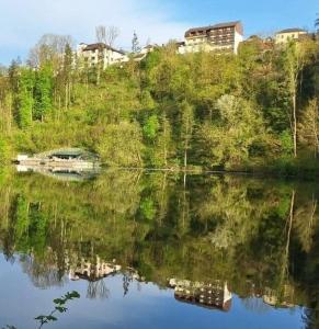 un reflejo de una casa en una colina junto a un lago en Hotel - Café - Konditorei Schröckmayr-Kastner en Neufelden