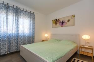 Lavender, Lighthouse, Sunrise Apartments - Kuća&More House No13 في كرك: غرفة نوم بسرير والستائر زرقاء