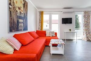 Lavender, Lighthouse, Sunrise Apartments - Kuća&More House No13 في كرك: غرفة معيشة مع أريكة حمراء وتلفزيون