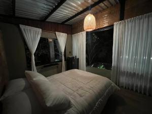 a bedroom with a large bed and a window at Entremonte Cabañas in La Vega