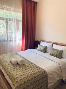 a bedroom with a bed with two towels on it at Korenishuli Veranda Wine Hotel in Tsʼageri