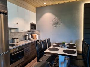 a kitchen with a table and chairs in a kitchen at Chalet Ellivuori huoneisto as 1 in Sastamala +24 photos