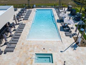 an overhead view of a swimming pool with chaises and chairs at Modern and Luxury 4 suites Villa near Disney 7521 in Orlando