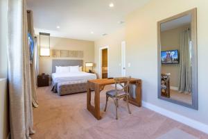 a hotel room with a bed and a table and a mirror at Modern and Luxury 4 suites Villa near Disney 7521 in Orlando