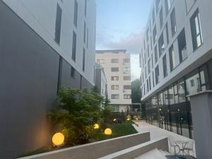 uma vista para um beco entre dois edifícios altos em Harmony property WIN HERASTRAU em Bucareste