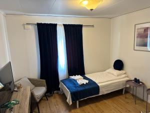 ein Schlafzimmer mit einem Bett, einem Sofa und einem Fenster in der Unterkunft Hotell Lamar in Ängelholm