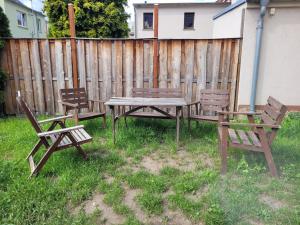Tres bancos y una mesa de picnic frente a una valla. en Monteurswohnung Roßwein - Zentral - Küche, en Roßwein