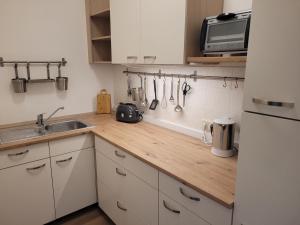 Una cocina con gabinetes blancos y una encimera de madera. en Monteurswohnung Roßwein - Zentral - Küche, en Roßwein