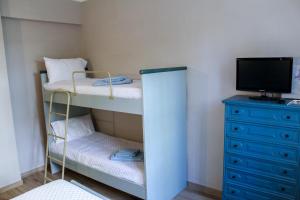 a small bedroom with two bunk beds and a television at La Stella di Via Venezia in Marina di Carrara