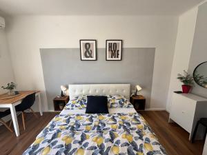a bedroom with a bed and two pictures on the wall at Studio Apartman LEMON in Dubrovnik