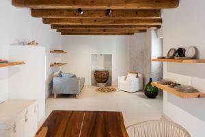 a living room with white walls and wooden ceilings at The Mini Beach Hotel in Stalos