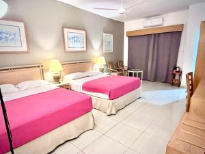 pokój hotelowy z 2 łóżkami i różową pościelą w obiekcie Masaya Hurghada Rooms w mieście Hurghada