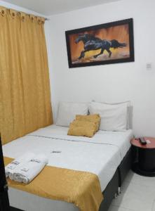 1 dormitorio con 1 cama con una foto de un caballo en la pared en Hotel Casa Nini, en Bogotá