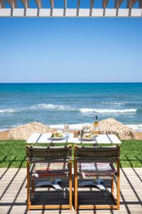stół z dwoma krzesłami i ocean w tle w obiekcie The Mini Beach Hotel w Stalós