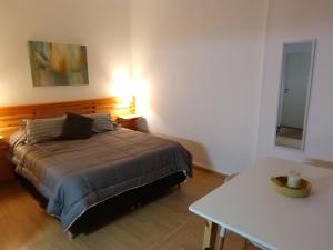 1 dormitorio con cama, mesa y espejo en Solar del Tajamar en Alta Gracia