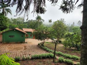 a green house in the middle of a field at Pousada La na Roça in Paraisópolis