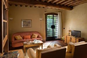 uma sala de estar com um sofá e uma mesa em Il Coltro em San Gimignano