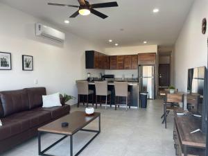 a living room with a couch and a kitchen at Oceanview Condo / Rooftop pool in Cabo San Lucas