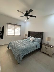 Un dormitorio con una cama y un ventilador de techo. en Oceanview Condo / Rooftop pool, en Cabo San Lucas