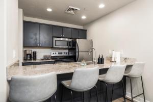 a kitchen with a counter with four chairs at a bar at Cozy Condo Downtown Salt Lake City in Salt Lake City