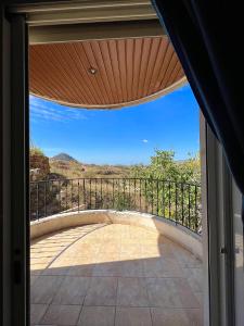 eine offene Tür zu einem Balkon mit Aussicht in der Unterkunft Olympia in Kfardebian