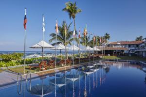 una piscina con sedie e ombrelloni e la spiaggia di Coral Sands Hotel a Hikkaduwa