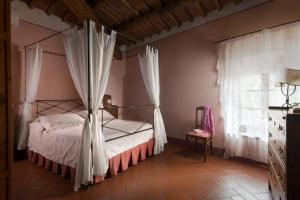 a bedroom with a canopy bed and a window at Il Coltro in San Gimignano